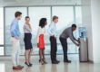 business-people-standing-by-water-cooler-at-office